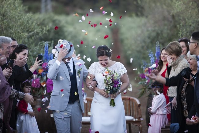 Bride and groom under a shower of rose petals at their wedding in Ibiza, Spain